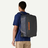Patagonia Black Hole® MLC® Wheelie suitcase with black durable fabric, large wheels, and retractable handle for travel.