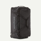 Black Patagonia Black Hole® Wheeled Duffel Bag 70L with sturdy wheels, durable black fabric, and spacious design for travel.