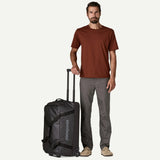 Patagonia Black Hole® Wheeled Duffel Bag 70L showing durable black fabric, wheels, telescoping handle, and spacious main compartment.