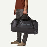 Patagonia Black Hole® Wheeled Duffel Bag 70L in black with handles and wheels, showing durable, water-resistant fabric.