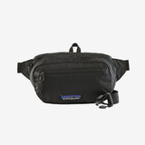 Patagonia Ultralight Black Hole Mini Hip Pack in blue with Patagonia patch, compact 1L water-resistant travel and outdoor accessory.
