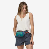 Patagonia Ultralight Black Hole Mini Hip Pack in patchwork subtidal blue with logo patch, compact and lightweight for outdoor use.