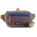 Patagonia Ultralight Black Hole Mini Hip Pack in patchwork subtidal blue, 1L, with adjustable strap and exterior zip pocket.