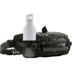 Shiny black Patagonia Black Hole® Waist Pack 5L with adjustable strap and zippered compartments for outdoor storage.