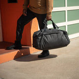 Black Peak Design Travel Duffel 65L with multiple zippered compartments and sturdy handles, designed for durable travel storage.