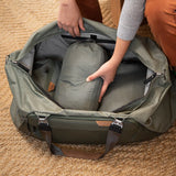 Black Peak Design Travel Duffel 65L with sturdy handles and adjustable shoulder strap, spacious for travel and gear storage.