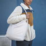 Peak Design packable tote bag shown folded and expanded, featuring durable fabric and compact design for versatile carrying.
