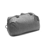 Peak Design Shoe Pouch in sage green, compact travel bag with zipper closure and adjustable strap for organizing shoes.