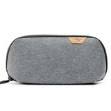 Small charcoal Peak Design Tech Pouch Small used as a compact tech kit with multiple compartments and zippers.