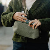 Small Peak Design Tech Pouch in sage green, showing compact tech kit with multiple compartments and zipper closure.