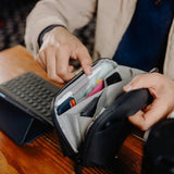Small Peak Design Tech Pouch in sage, showing organized interior with compartments for tech accessories and gadgets.