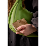 Secrid Miniwallet Pebble in Cappuccino color with green bag, showing compact leather wallet with card slots and sleek design.