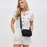 Black woven neoprene crossbody bag by Sol & Selene with adjustable strap and minimalist design.