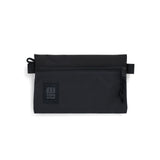 Small black accessory bag by Topo Designs with a compact design and durable zipper for organizing essentials.