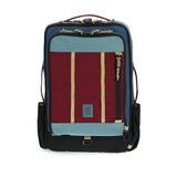 Topo Designs Global Travel Bag 30L backpack in dark denim and burgundy with front zip pocket and adjustable straps.