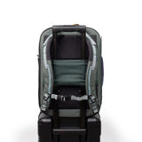 Topo Designs Global Travel Backpack with multiple compartments, adjustable straps, and durable fabric, shown on a person in outdoor setting.