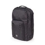 Topo Designs Global Pro Backpack in black, with multiple compartments and padded straps, shown from a side angle.
