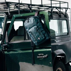 Topo Designs Global Pro Backpack shown in black with multiple compartments and adjustable straps, ideal for travel and daily use.