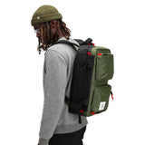Topo Designs Global Briefcase in green and black with detailed stitching and sturdy handle, showcasing its professional leather exterior.