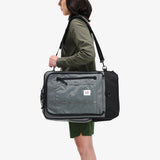 Olive green Topo Designs Global Travel Bag 40L carry-on luggage with multiple compartments and sturdy handles, ready for travel.