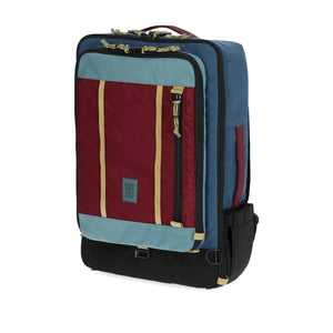 Topo Designs Global Travel Bag 40L carry-on luggage in dark denim and burgundy with multiple compartments and durable fabric.