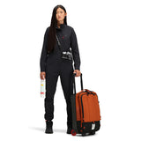 Topo Designs Global Travel Bag roller carry-on luggage in black and burgundy, front view showing durable design and handle.