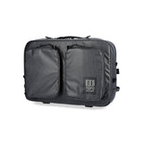 Black Topo Designs Apex Briefcase, a convertible leather bag with handles and shoulder strap, designed for versatile carrying.