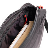 Topo Designs Block Bag crossbody bag with adjustable strap, durable fabric, and front pocket, shown in a close-up view.