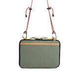 Back view of Topo Designs All Adventure Accessory Bag, a compact crossbody bag in beetle color with adjustable strap and zippered compartments.