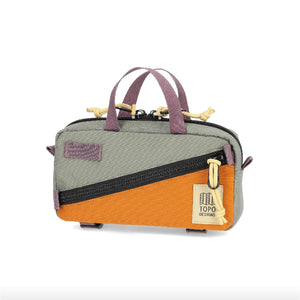 Topo Designs Mini Quick Pack crossbody bag with adjustable strap and compact design, shown in a natural outdoor setting.