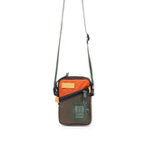 Topo Designs mini shoulder bag crossbody bag with adjustable strap and durable fabric, shown in a natural outdoor setting.