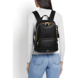 Tumi Voyageur Hannah leather backpack with adjustable straps and multiple compartments, placed on a neutral background.