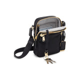 Black Tumi Voyageur Persia Crossbody bag with gold accents, featuring adjustable strap and sleek design for everyday use.