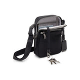 Black Tumi Voyageur Persia Crossbody bag with gold accents, featuring sleek design and adjustable strap.