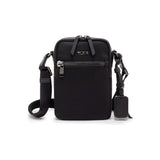 Black Tumi Voyageur Persia Crossbody bag with gold accents, showcasing its compact design and stylish exterior.