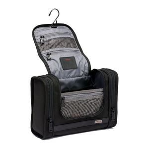 Black Tumi Alpha hanging travel kit with multiple compartments and zipper closures for organized travel storage.