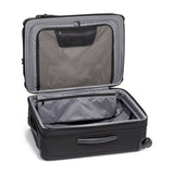 Black Tumi Alpha Short Trip expandable 4-wheeled packing case with black hardware, designed for travel and easy maneuverability.