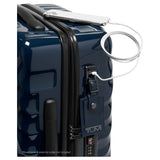 Navy Tumi 19 Degree polycarbonate carry-on luggage with four wheels and telescopic handle, designed for international travel.