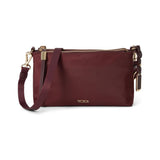 Black Tumi Voyageur Adela crossbody bag with gunmetal hardware, featuring sleek design and adjustable strap for versatile style.