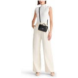 Black Tumi Voyageur Lex small train case crossbody bag with gold accents, compact and stylish for travel and everyday use.