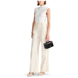 Black Tumi Voyageur Lex Small Train Case Crossbody Bag with gold hardware, compact design, and adjustable strap.