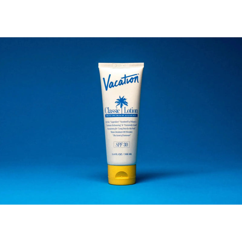 Bottle of Vacation Classic Lotion SPF 30 sunscreen with lotion texture, featuring a white cap and label, on a clean background.