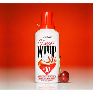 Bottle of Vacation Classic Whip SPF 30 sunscreen with white cap and label, showing the product's packaging and branding.