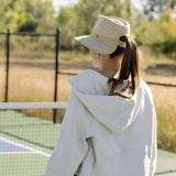 Beige Wallaroo Gabi UPF 50+ packable hat with wide brim and adjustable chin strap for sun protection and outdoor wear.