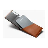 Bellroy travel wallet in caramel leather, showing multiple card slots, cash compartment, and sleek compact design.