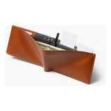 Bellroy travel wallet in caramel leather showing multiple card slots and a cash compartment on a neutral background