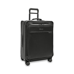 Briggs & Riley Baseline medium expandable spinner suitcase with blue exterior, four spinner wheels, and telescoping handle for travel.