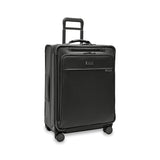 Briggs & Riley Baseline medium expandable spinner suitcase with blue exterior, four spinner wheels, and telescoping handle for travel.