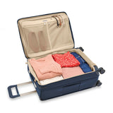 Briggs & Riley Baseline medium expandable spinner suitcase with blue exterior, four wheels, and a telescoping handle.