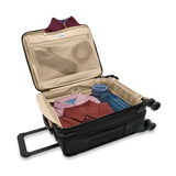Briggs & Riley Baseline compact carry-on spinner luggage in blue with four wheels and a telescoping handle for easy travel.